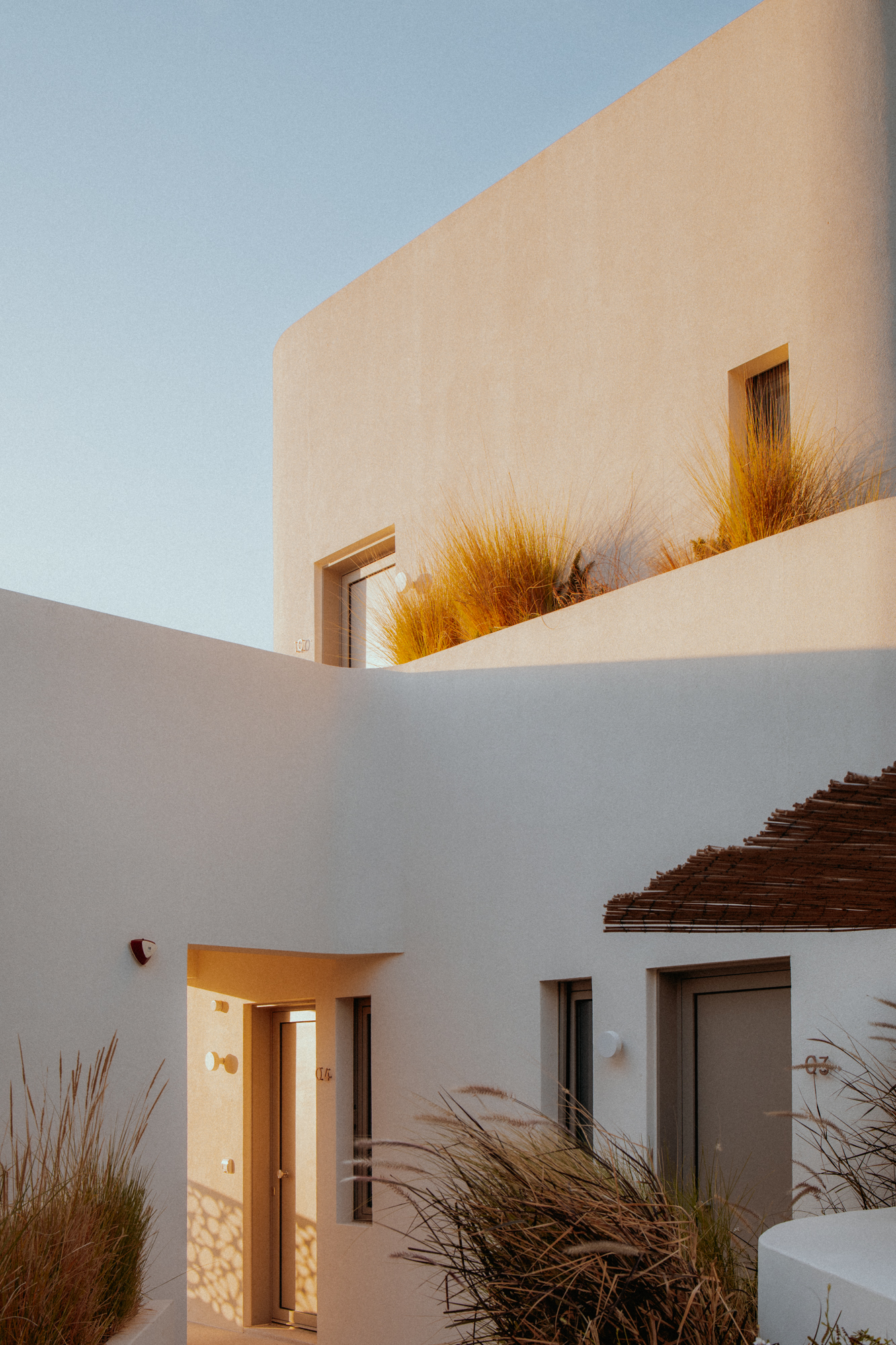 grecka architektura nowoczesna White Pebble Suits Milos trawy na balkonie widok boczny